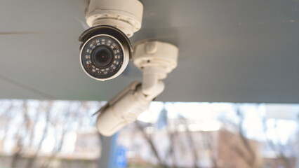 Outdoor CCTV Cameras. Two white cameras of residential neighborhood security system close-up....