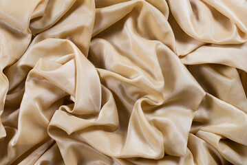 Beige silk fabric wavy, beautiful background of silk beige, golden fabric