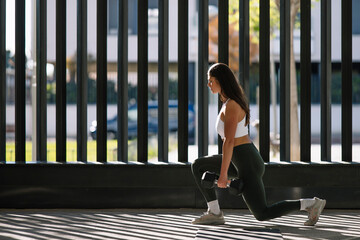 Young woman exercising with dumbbell at home