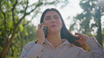 Positive lady enjoy phone conversation in summer park closeup. Woman talking