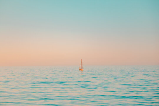 Iconic Pastel Sunset with Single Sailboat