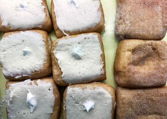 Square filled donuts with white icing and cinnamon sugar