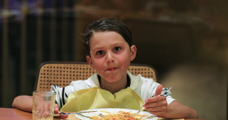 Child eating spaghetti for dinner young boy eating supper