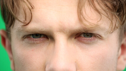 Man's eyes, close-up, on a green background