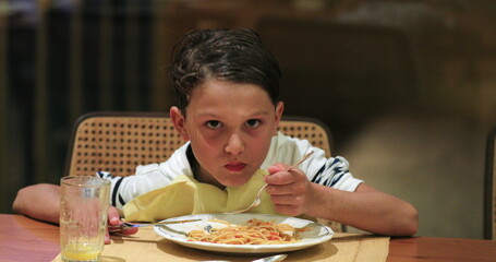 Child eating spaghetti for dinner young boy eating supper