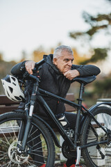 Man Sitting on Bench Next to Bicycle