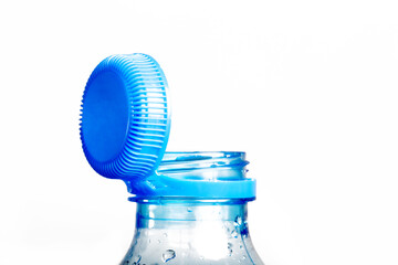 Close up of new cap attached to plastic bottle, connected to the neck of the bottle by solid tab attached to safety ring. They are intended to encourage recycling, as part of the fight against litter.