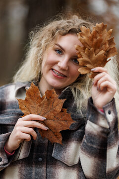 Portrait of a Woman Holding a Leaf and Smiling at Camera