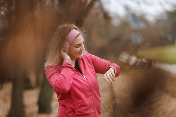 Woman Checking Her Smartwatch During Autumn Park Workout