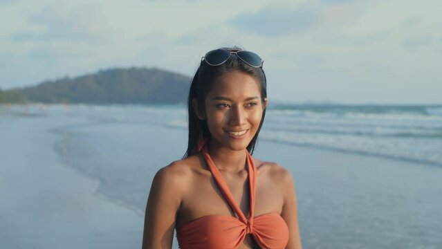 Holiday concept of 4k Resolution. Young Asian woman in swimsuit taking a walk on the beach.