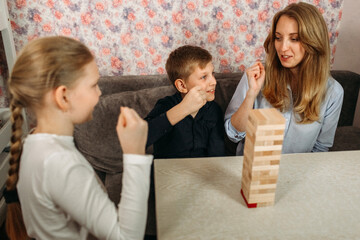 Woman and Two Children Playing With Wooden Block Tower