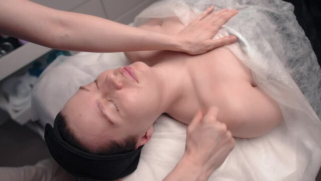 Relaxed woman lies on spa table for massage at luxury spa resort. Health, stress relief and rejuvenation concept
