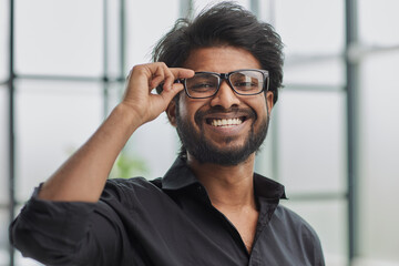 Funny vintage style guy adjusting his glasses and smiling