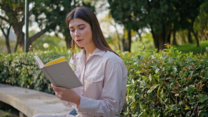 Intelligent woman enjoy book sitting green park closeup. Lady reading novel 