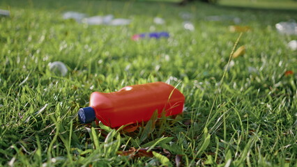 Plastic bottle lying discarded on grass highlighting pollution problem closeup