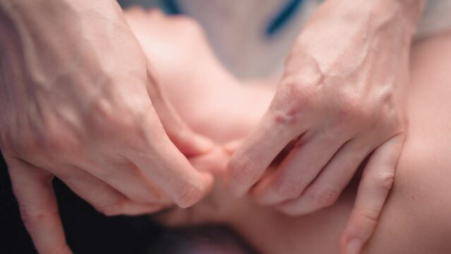 close up of unrecognizable female hands of masseur giving therapeutic neck massage to woman lying on massage couch in massage spa center