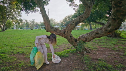 Conscious girl picking trash demonstrating environmental responsibility. 