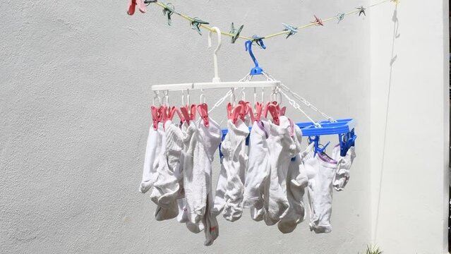 White socks hung outside on clothesline to dry in sunlight