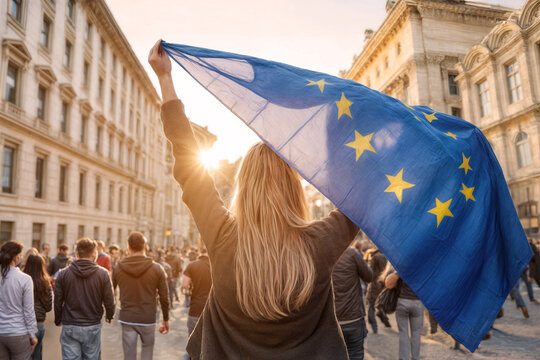 Junge Frau hält eine wehende EU Flagge auf einer Demonstration in einer europäischen Stadt hoch