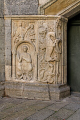 bassorilievi scolpiti a lato del portale posteriore della chiesa di San Fedele a Como