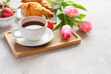 Happy mother's day, beautiful breakfast, lunch with cup of coffee (cappuccino) fresh croissants, strawberries on tray, bouquet of tulips as gift. - obrazy, fototapety, plakaty