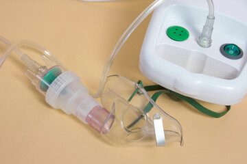 A medical inhalation device with a tube attached to it. The device is white and has a green cord - obrazy, fototapety, plakaty
