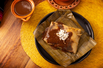 Oaxacan Tamale. Prehispanic dish typical of Mexico and some Latin American countries. Corn dough wrapped in banana leaves. The tamales are steamed. - 793262074