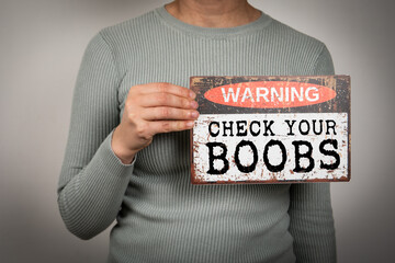 Check your boobs. Warning sign with text in a woman's hand - 793268890
