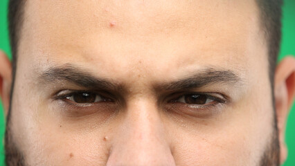 Fototapeta premium Man's eyes, close-up, on a green background