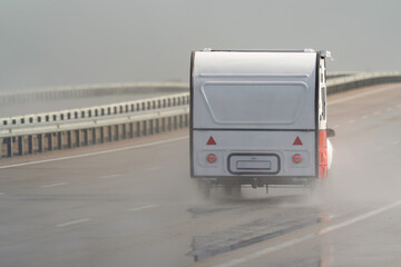 Caravan driving on the motorway in the rain. Motorway in the rain.