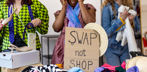 Friends trying clothes, glasses on home swap party - clothing exchange, garage sale. Vintage...
