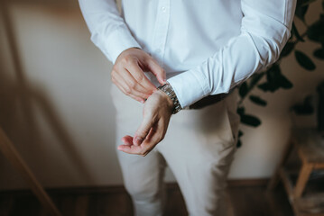 A young businessman is getting dressed for a business meeting.
