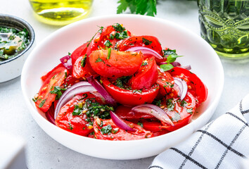 Summer juicy tomato salad with parsley dill garlic and olive oil dressing and red onion, white table background, top view - 793287637