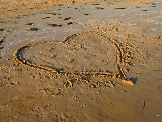 Cuore disegnato sulla sabbia in riva al mare 1414