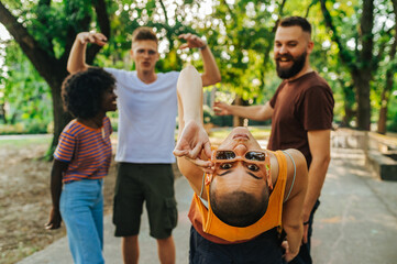 A hipster woman is posing with her interracial friends in a park.