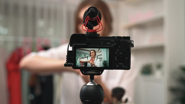 Rear view behide camera screen display influencer shoot live streaming vlog video review makeup prim social media or blog. Girl with cosmetics studio lighting for marketing recording session online.