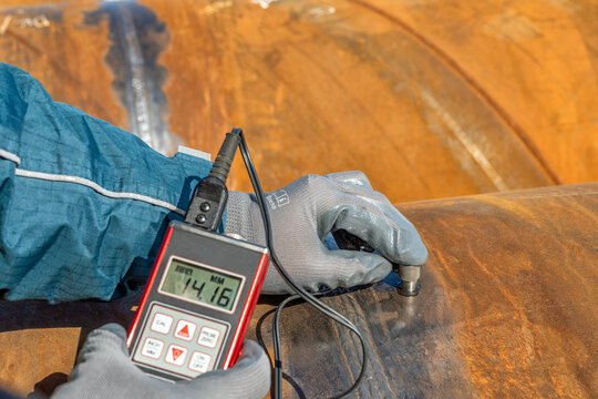 Technician is testing to pipe thickness with ultrasonic test method. Ultrasonic thickness measurement (UTM) is a method of performing non-destructive measurement (gauging) of the local thickness