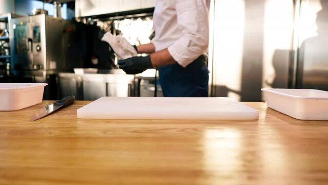 close-up in a professional kitchen of a chef's hands wiping a white board with towel