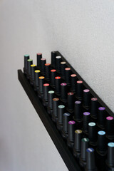 Fototapeta premium Shelves with black bottles with gel nail polish