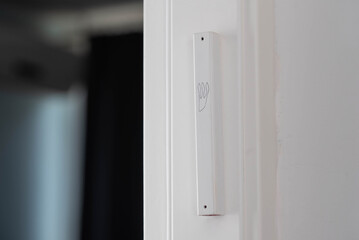 Jewish mezuzah on the doorpost, a prayer for home protection in Judaism. White interior, stylish...