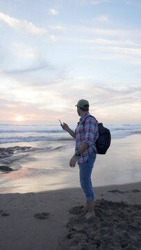 Hispanic guy solo traveler on the beach taking selfie happy on a beautiful sunset