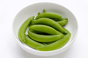 Fresh young green peas on white background.