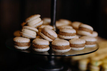 Macaroons Cakes with cream on a plate. Table with sweets, candies, dessert. Macaroons with chocolate