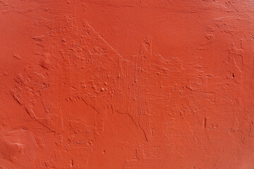 Detailed close-up of a rustic red wall with textured peeling paint suitable for backgrounds or...