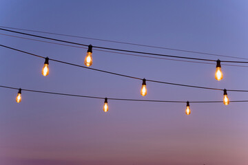 festive decor of yellow light bulbs. festive atmosphere. light bulbs in a row on a wire