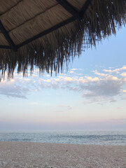 Fototapeta na wymiar Beautiful sunset in Cabo on sandy beach while sitting under beach umbrella 