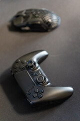 Gaming black game controller and mouse in the background.