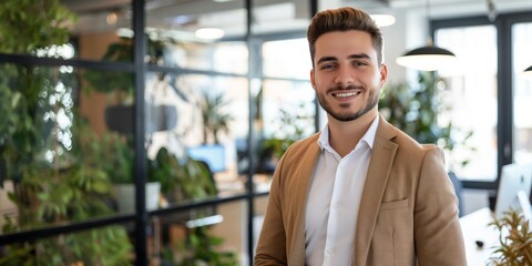 Smiling confident young businessman looking at camera standing in office. Elegant stylish corporate leader successful ceo executive manager.	