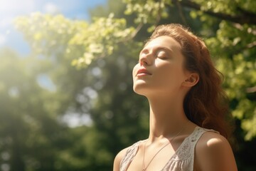 Fototapeta premium A woman is sitting in the sun, looking up at the sky. She is wearing a white tank top and has her hair down. Scene is peaceful and serene, as the woman is taking a moment to relax