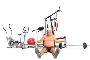 Mature man in sportswear sitting on the ground with fitness equipment